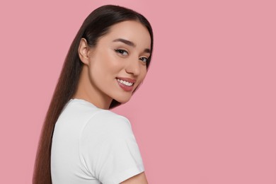 Photo of Portrait of beautiful young woman with elegant makeup on pink background. Space for text
