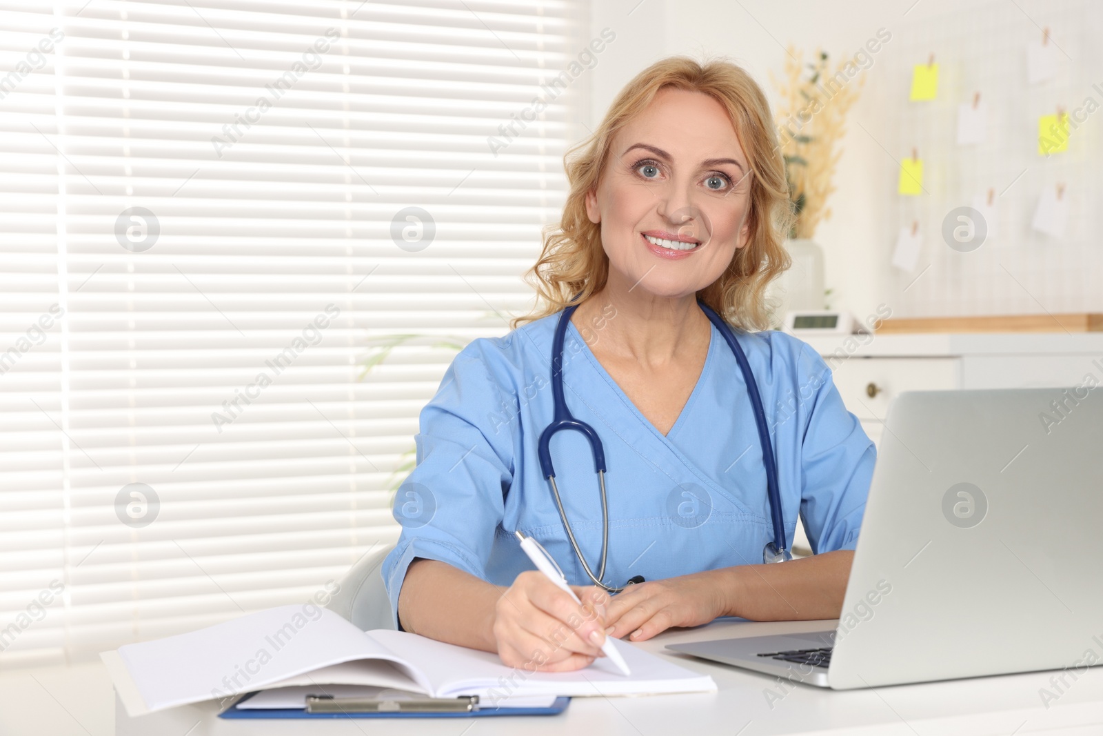 Photo of Portrait of doctor with laptop at workplace in clinic. Online medicine concept