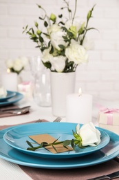 Photo of Elegant festive table setting with blank card in restaurant