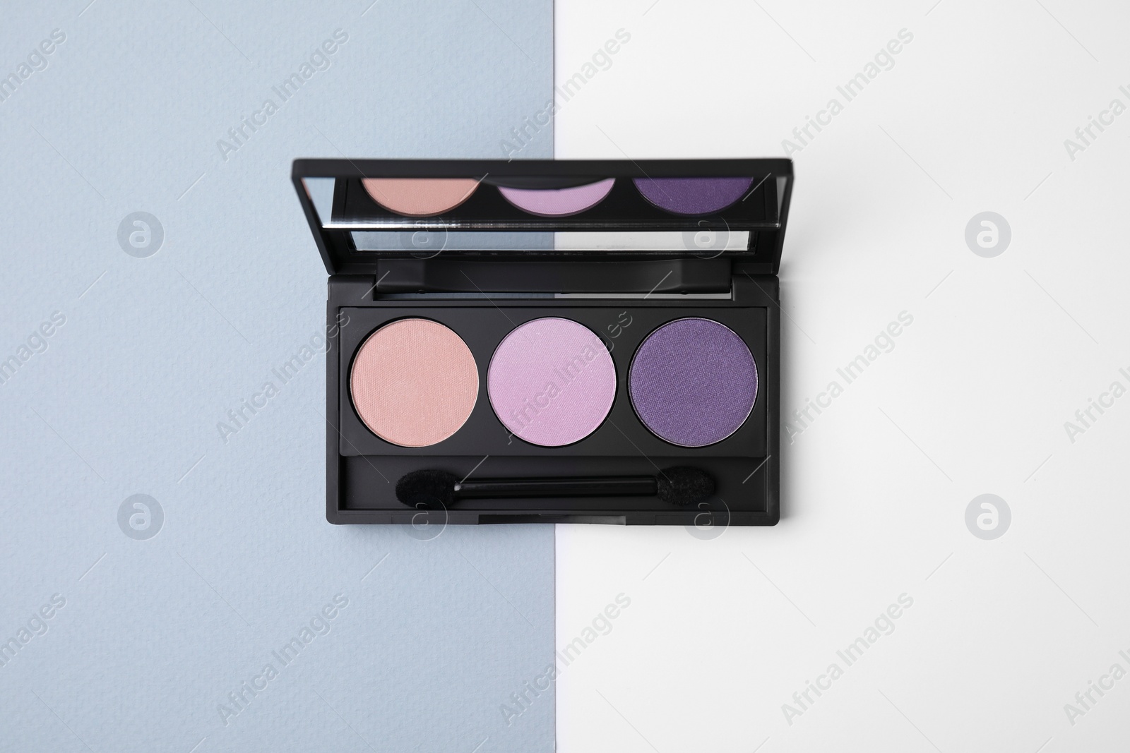 Photo of Eye shadow palette on colorful background, top view
