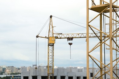 Construction site with tower crane near unfinished building