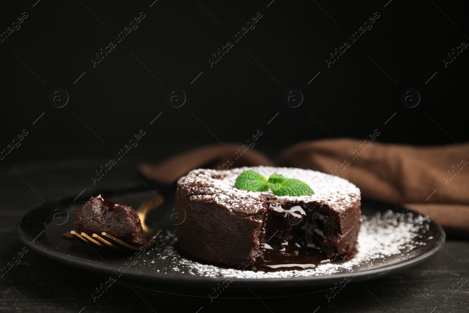 Photo of Delicious fresh fondant with hot chocolate and mint on black table, closeup