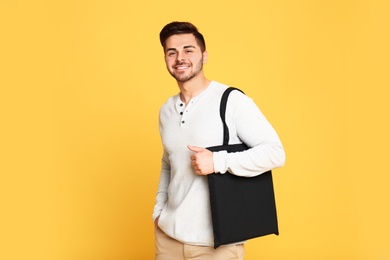 Photo of Portrait of young man with eco bag on yellow background. Space for text