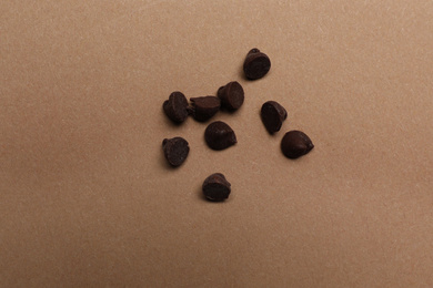 Photo of Delicious chocolate chips on brown background, top view