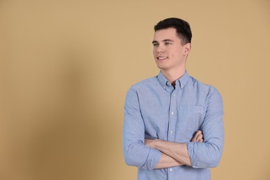 Portrait of handsome young man on beige background, space for text