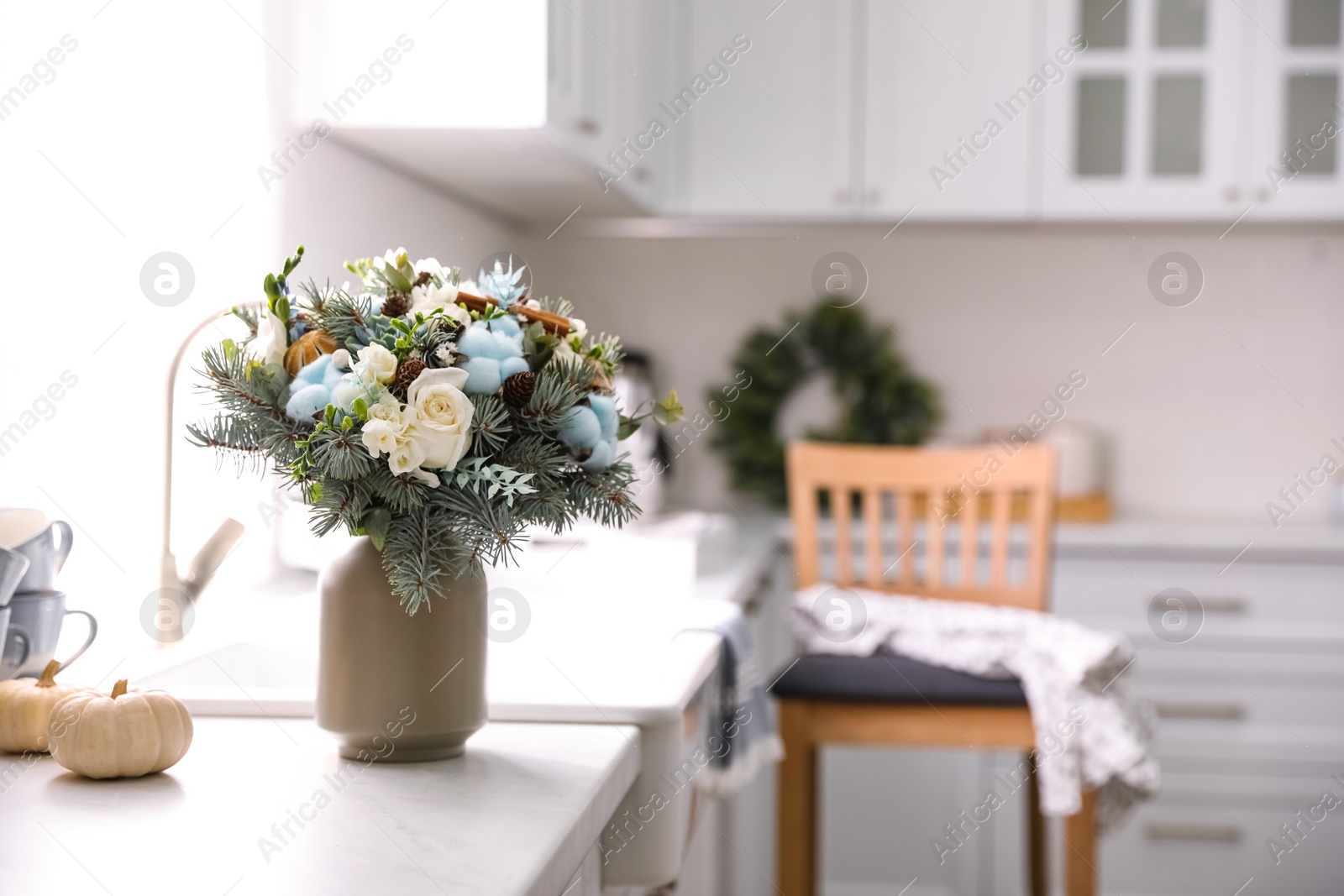 Photo of Beautiful winter bouquet on table in kitchen