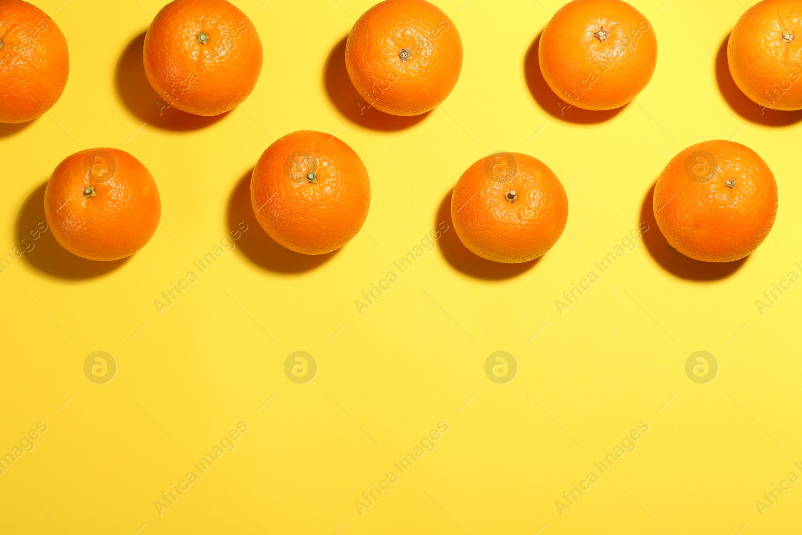 Photo of Flat lay composition with fresh ripe oranges on yellow background. Space for text