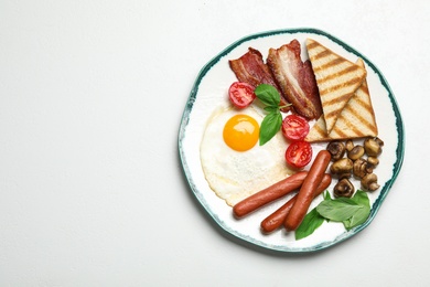 Breakfast with fried egg on light table, top view. Space for text