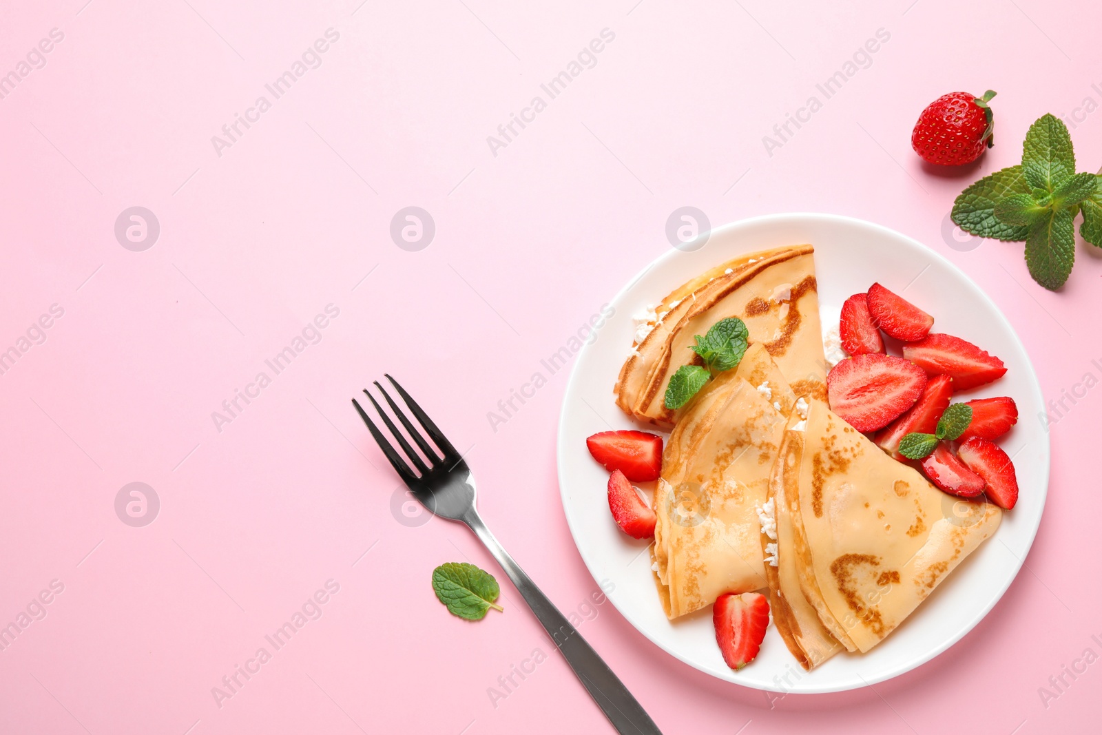 Photo of Delicious thin pancakes with strawberries and cottage cheese on pink background, flat lay. Space for text
