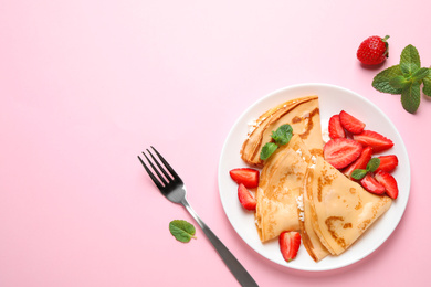 Delicious thin pancakes with strawberries and cottage cheese on pink background, flat lay. Space for text