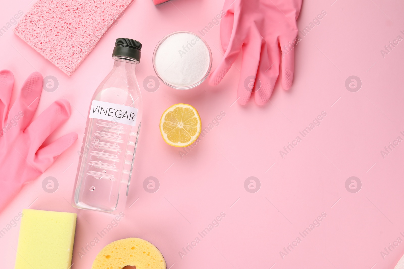 Photo of Eco friendly natural cleaners. Flat lay composition with bottle of vinegar on pink background, space for text