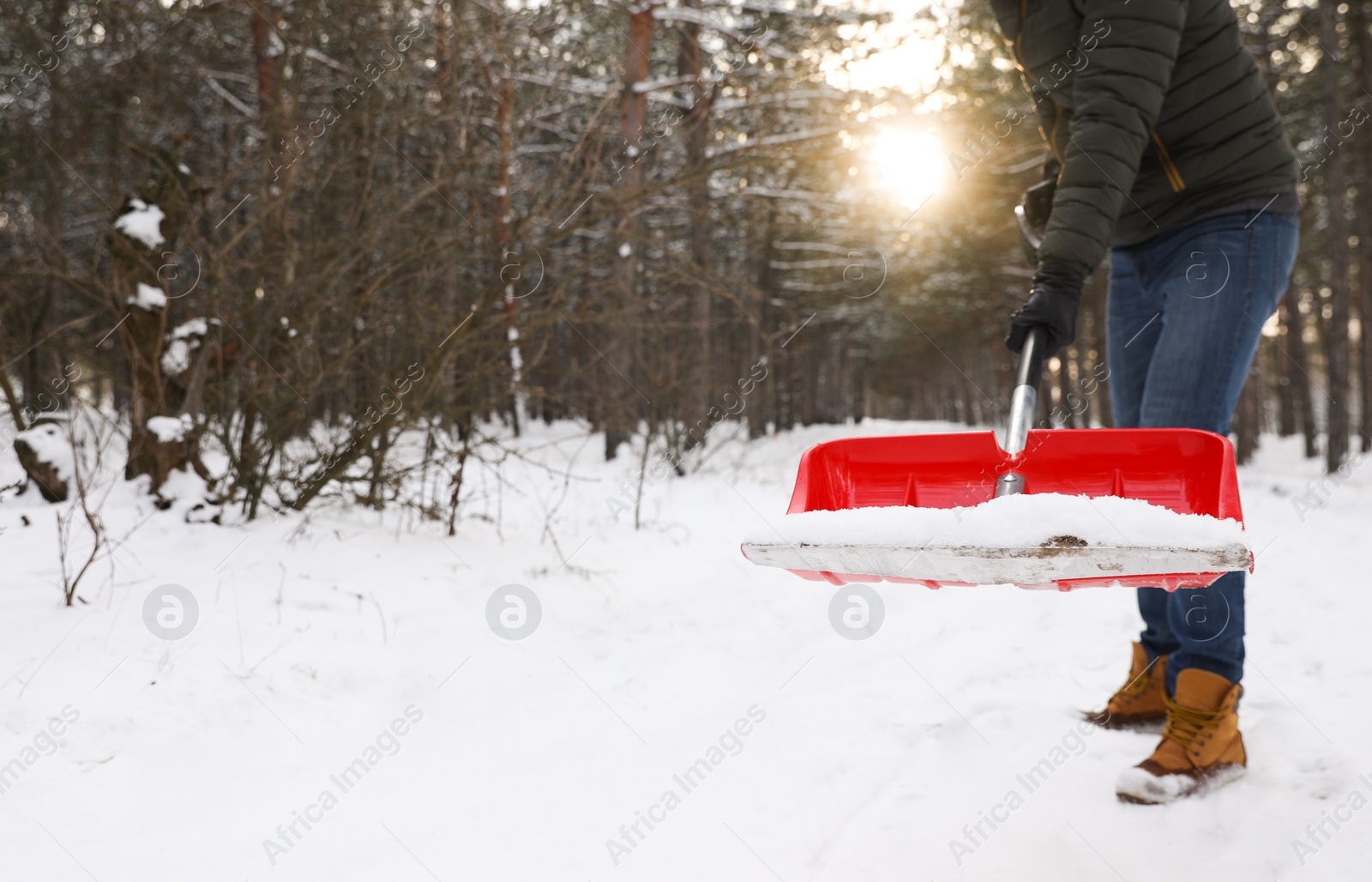 Photo of Man removing snow with shovel outdoors on winter day, closeup