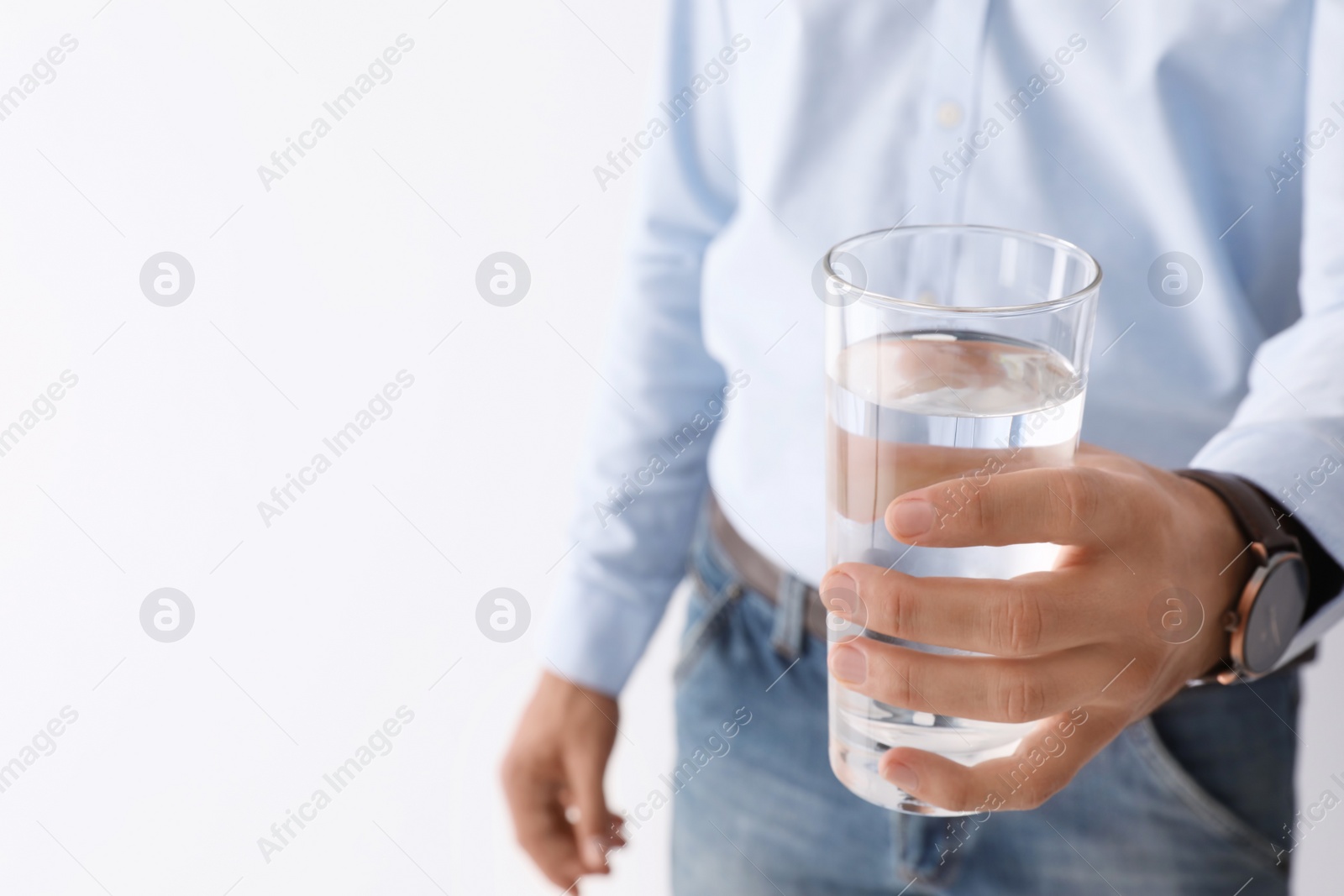 Photo of Man holding glass of pure water on white background, closeup. Space for text