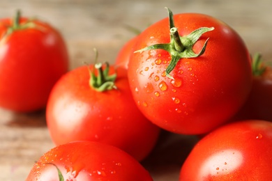 Photo of Fresh ripe tomatoes on wooden table, closeup