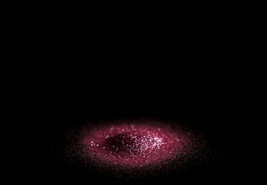 Photo of Heap of rose glitter with bokeh effect on black background