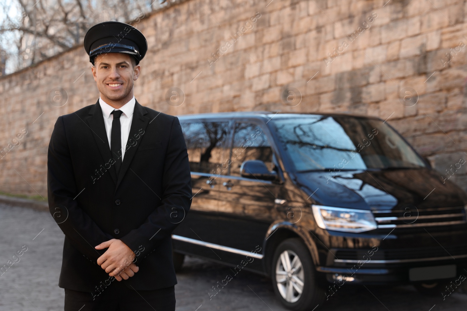 Photo of Professional driver near luxury car on street. Chauffeur service