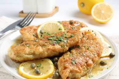 Delicious chicken piccata with herbs on table, closeup