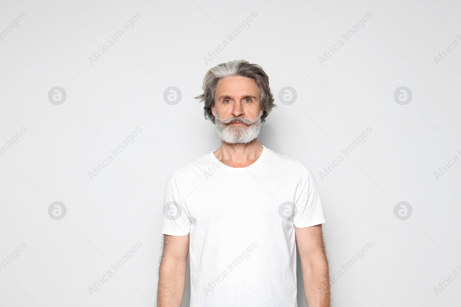 Photo of Portrait of mature man on light grey background, space for text