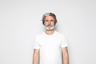 Photo of Portrait of mature man on light grey background, space for text