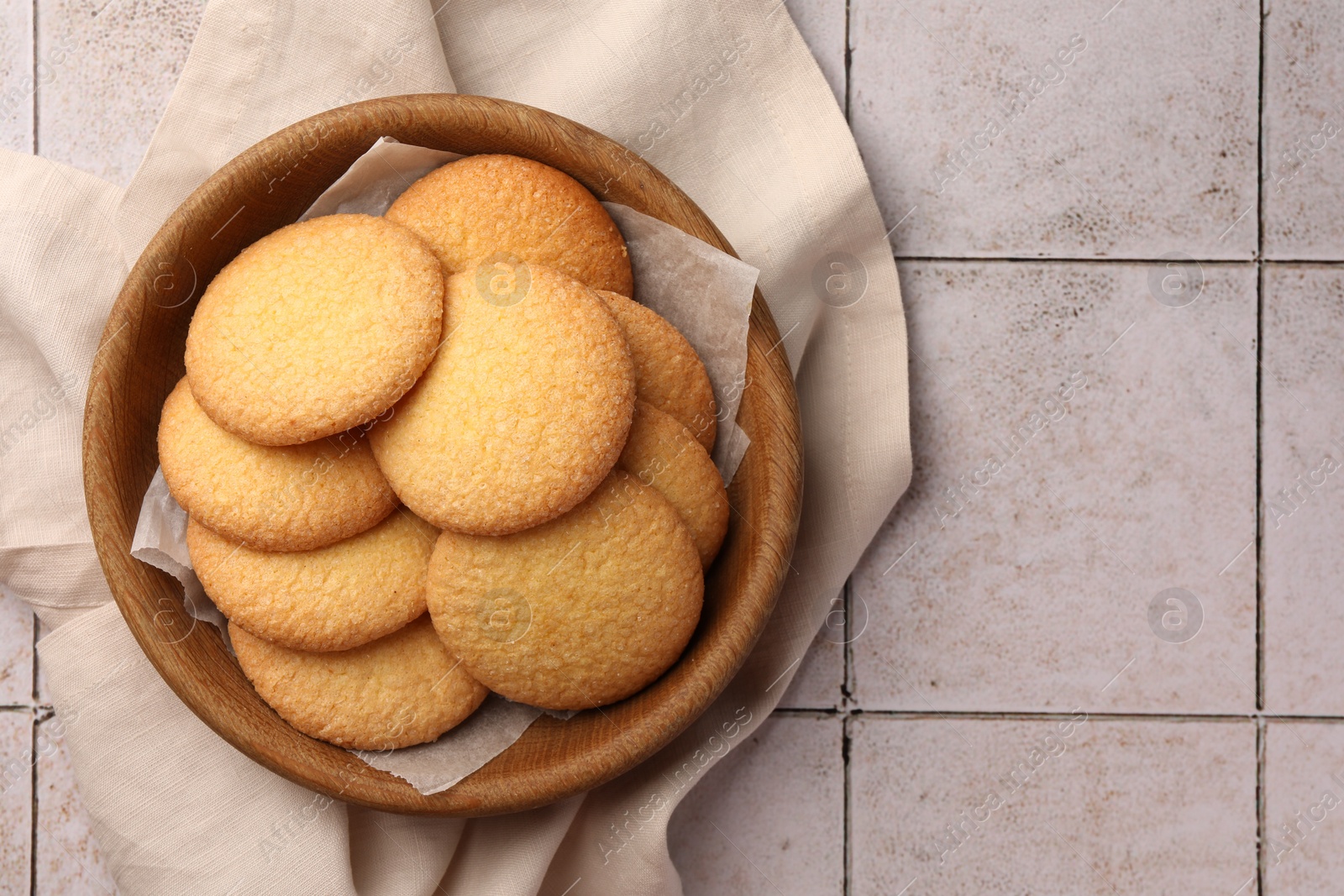 Photo of Delicious Danish butter cookies on white tiled table, top view. Space for text