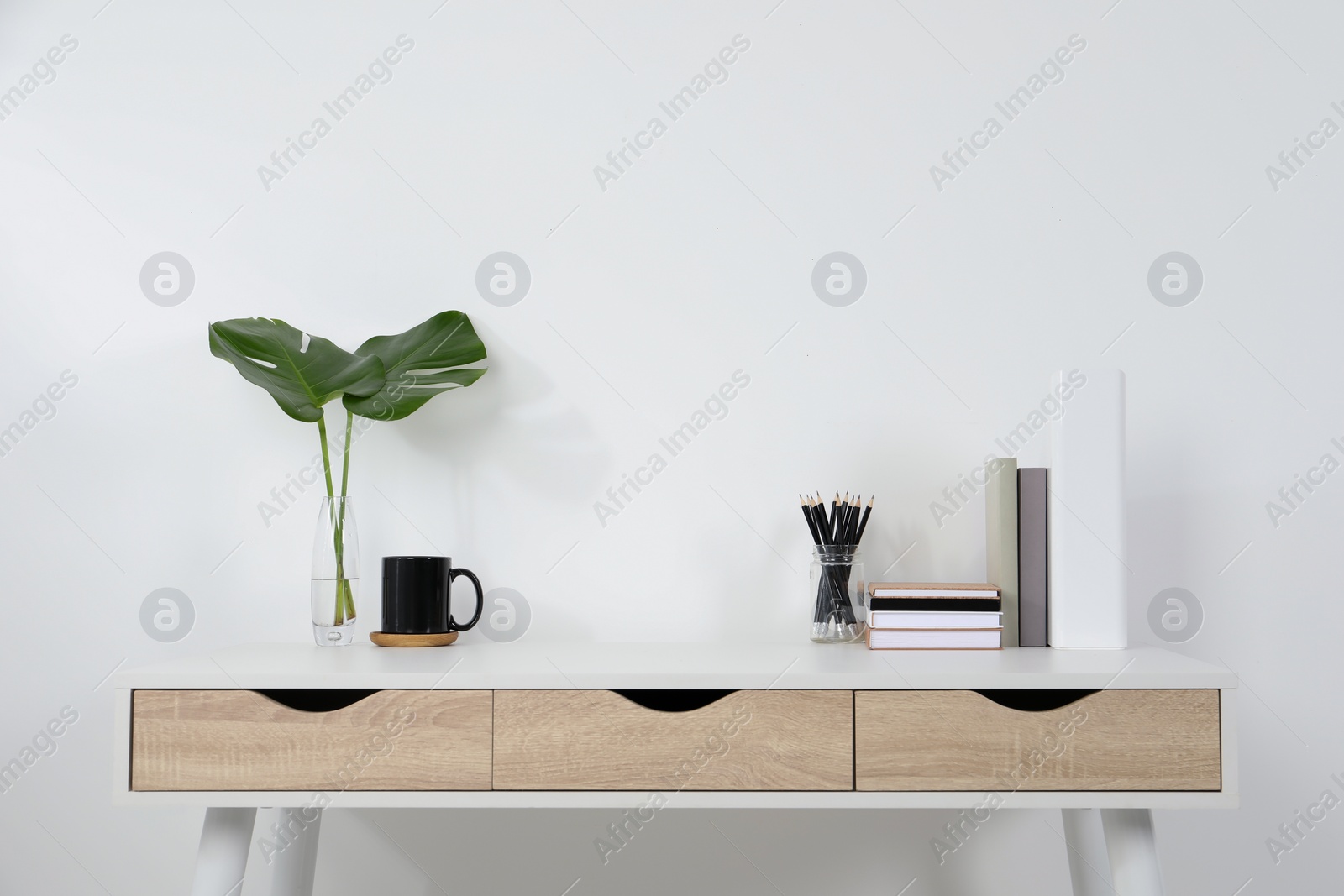 Photo of Comfortable workplace with white desk near wall