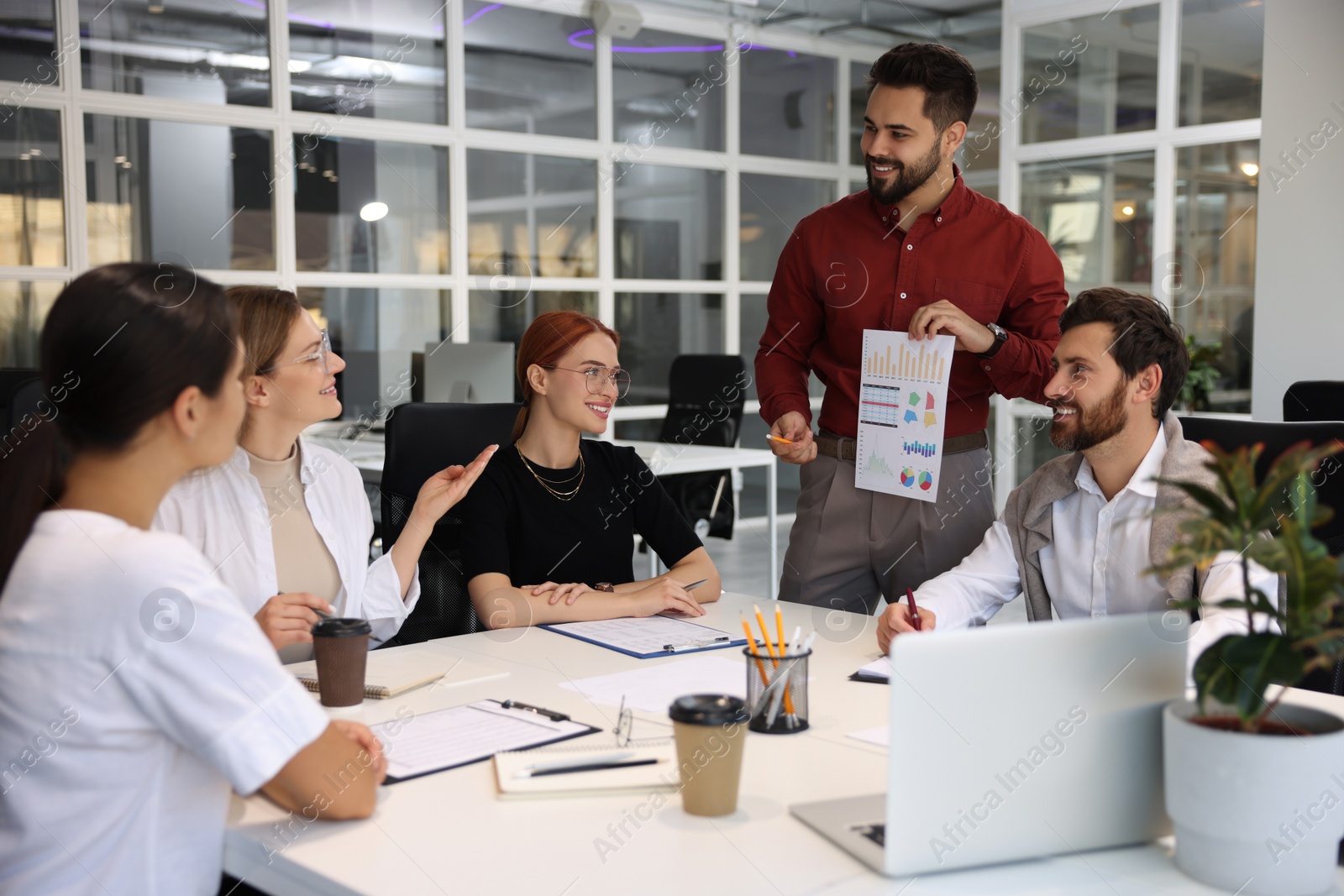 Photo of Team of employees working together in office