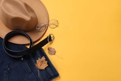 Flat lay composition with stylish hat on yellow background, space for text