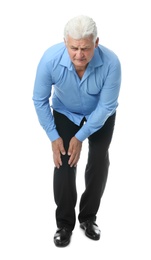 Full length portrait of senior man having knee problems on white background