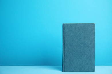 Photo of Hardcover book on blue background. Space for design