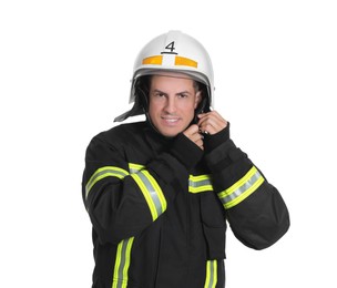 Portrait of firefighter in uniform wearing helmet on white background