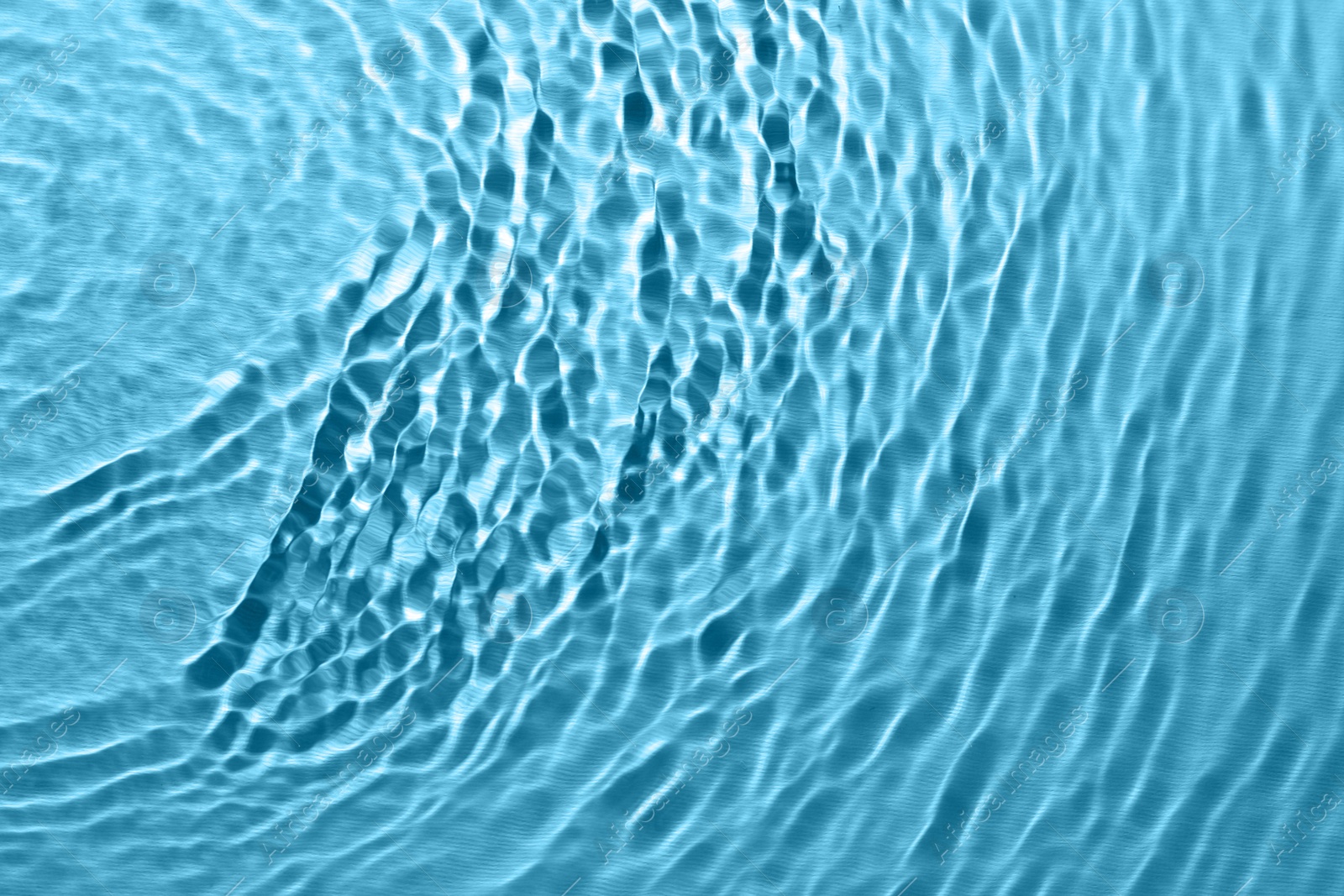 Image of Rippled surface of clear water on light blue background, top view