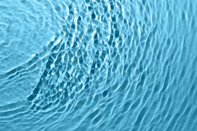 Rippled surface of clear water on light blue background, top view