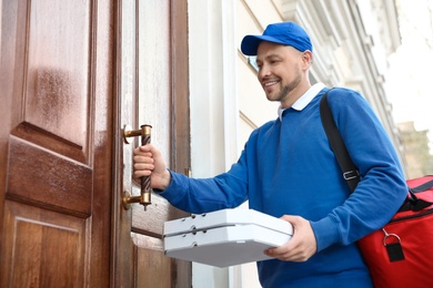 Photo of Male courier with order at entrance. Food delivery service