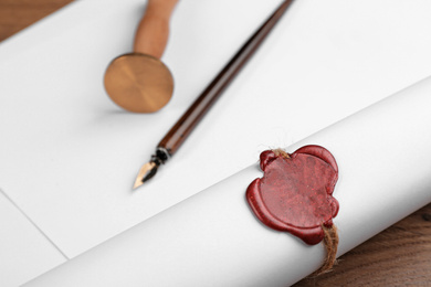 Document with notary's wax stamp on wooden table, closeup