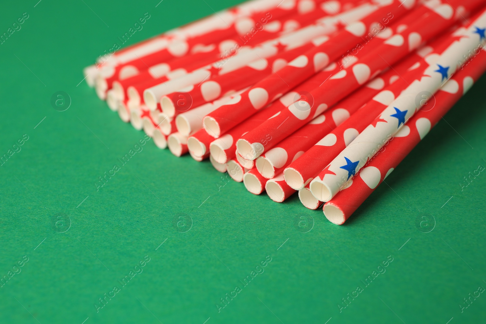 Photo of Many paper drinking straws on green background, closeup. Space for text