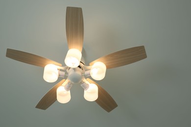 Ceiling fan with lamps indoors, low angle view