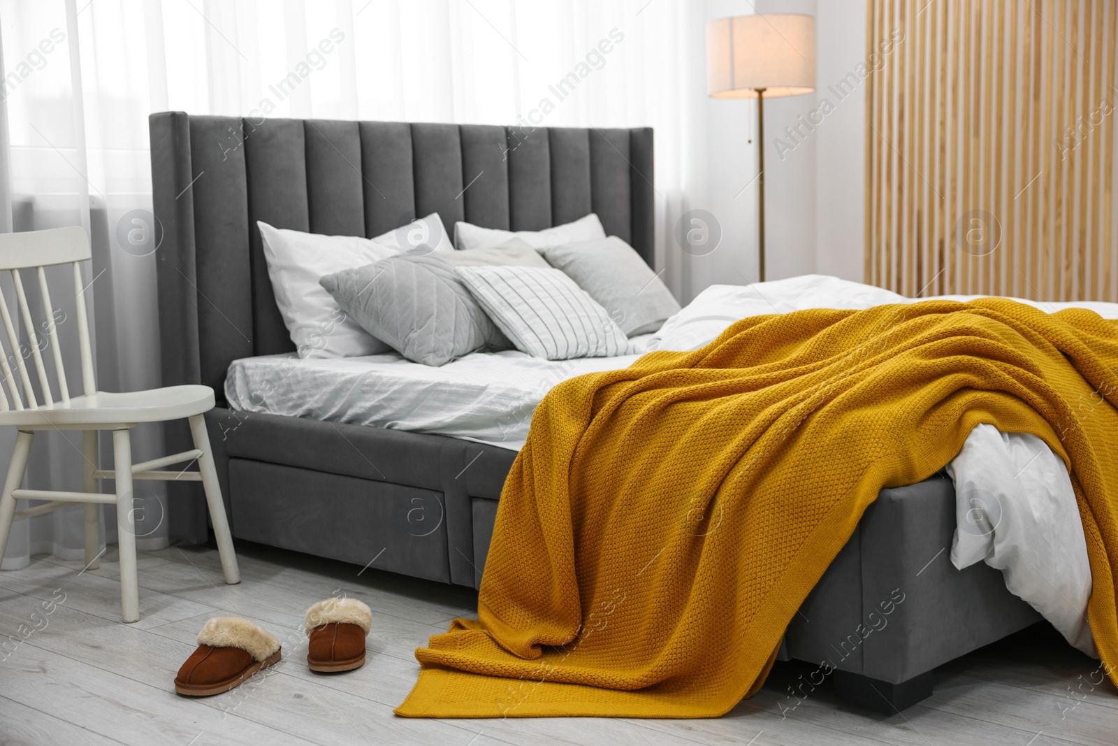 Photo of Bright plaid on bed in stylish bedroom