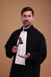 Judge with gavel on light brown background
