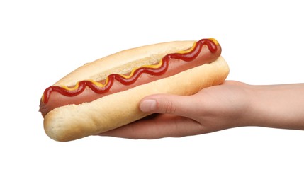 Woman holding delicious hot dog with mustard and ketchup on white background, closeup