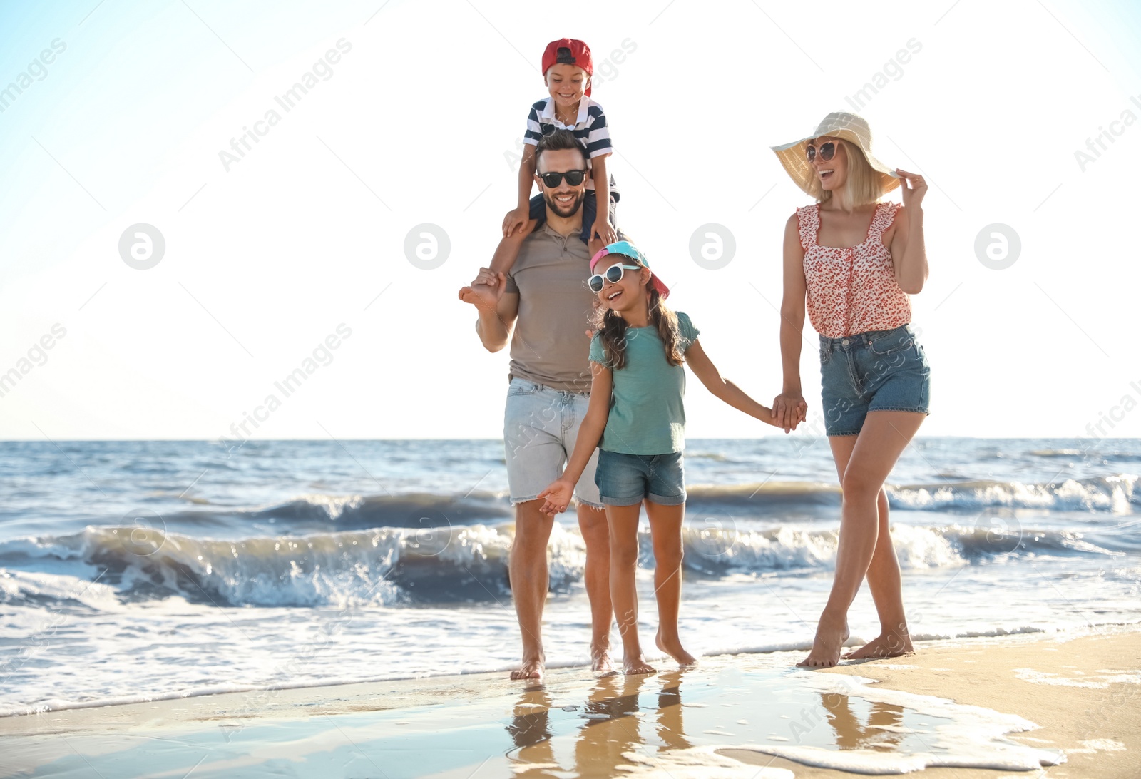 Photo of Happy family on sandy beach near sea