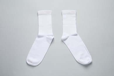 Pair of white socks on light grey background, flat lay