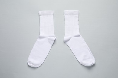 Photo of Pair of white socks on light grey background, flat lay