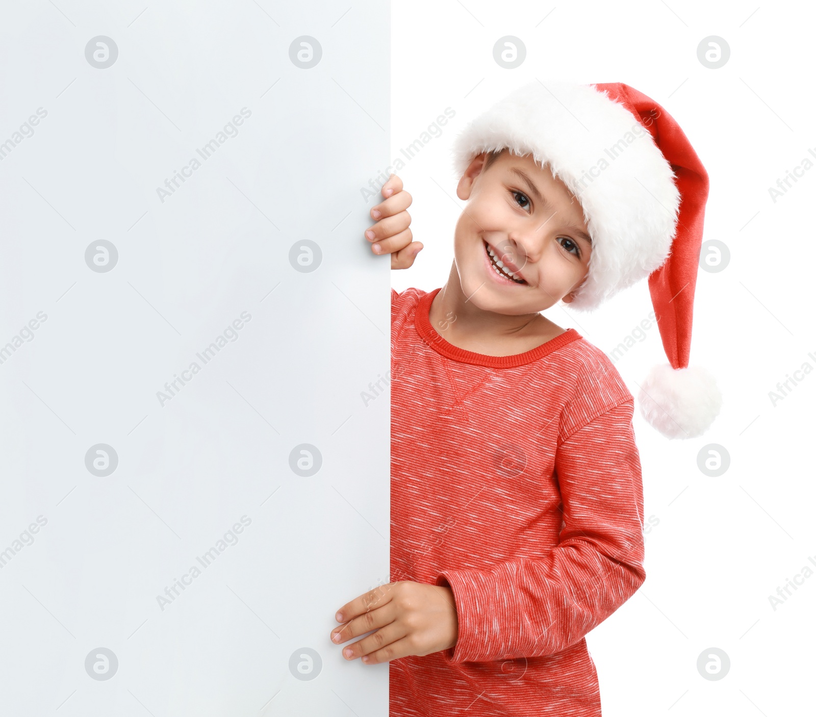 Photo of Cute little child wearing Santa hat on white background. Christmas holiday