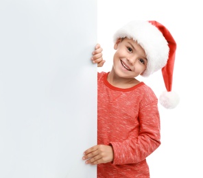 Cute little child wearing Santa hat on white background. Christmas holiday