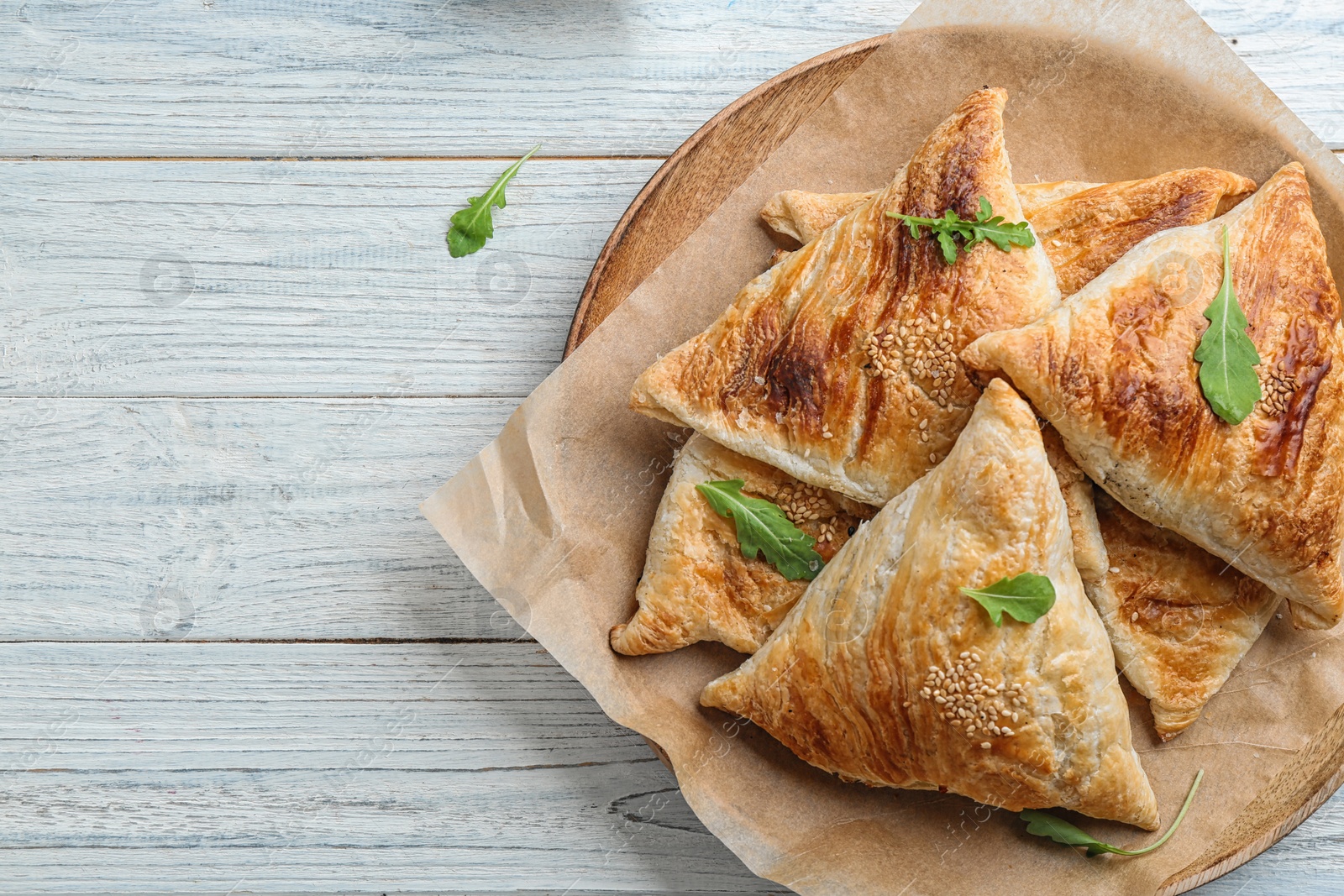 Photo of Fresh delicious puff pastry on white wooden table, top view. Space for text