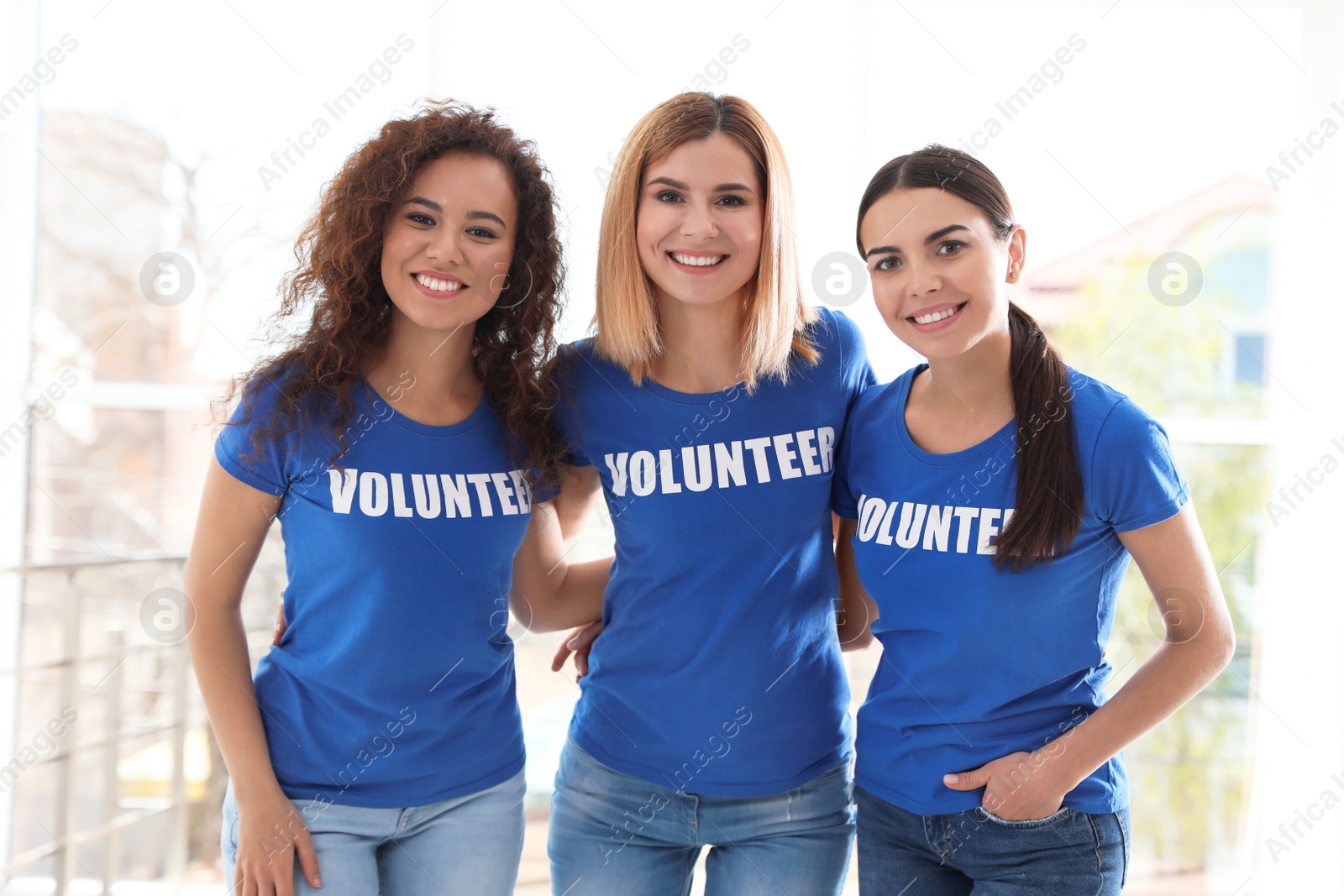 Photo of Portrait of happy female volunteers in uniform indoors