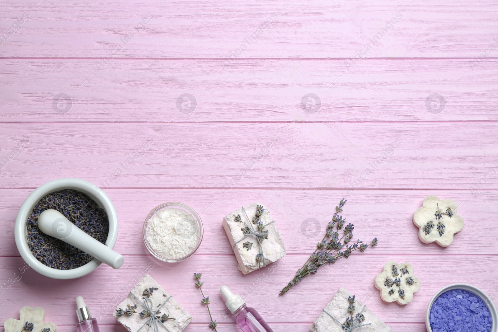 Photo of Flat lay composition with hand made soap bars and lavender flowers on pink wooden table, space for text