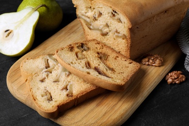 Tasty cut pear bread on black table, closeup. Homemade cake