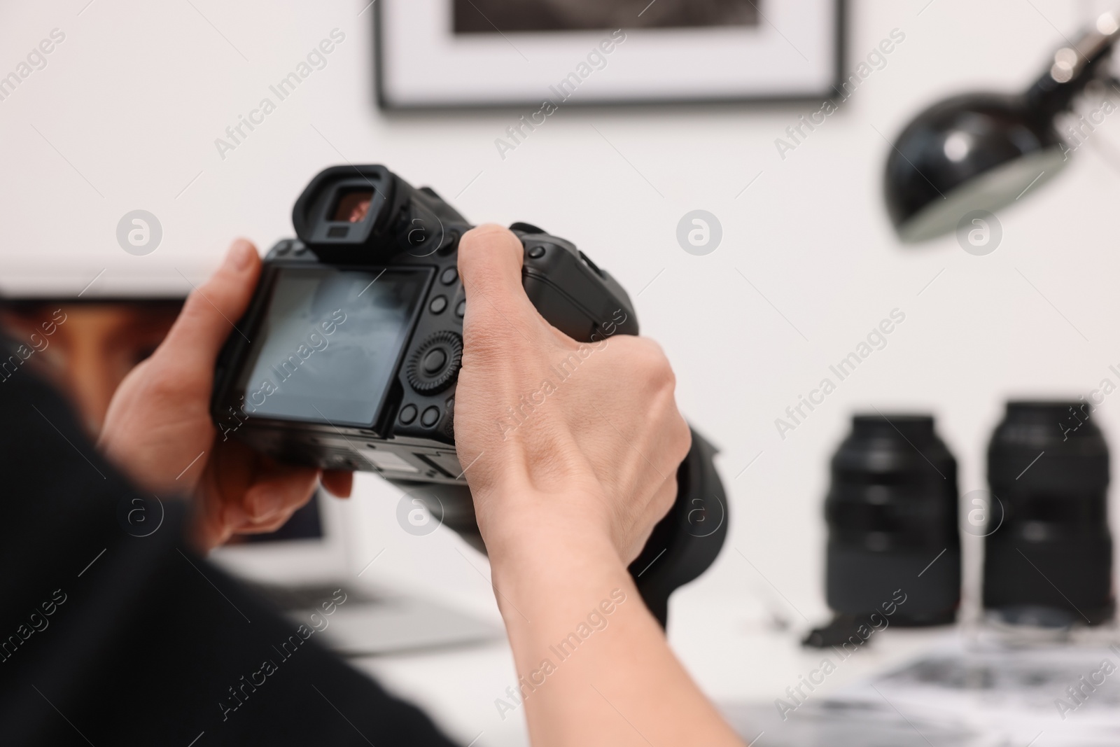 Photo of Professional photographer with digital camera indoors, closeup