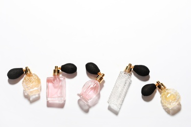 Photo of Different elegant perfume bottles on white background, top view